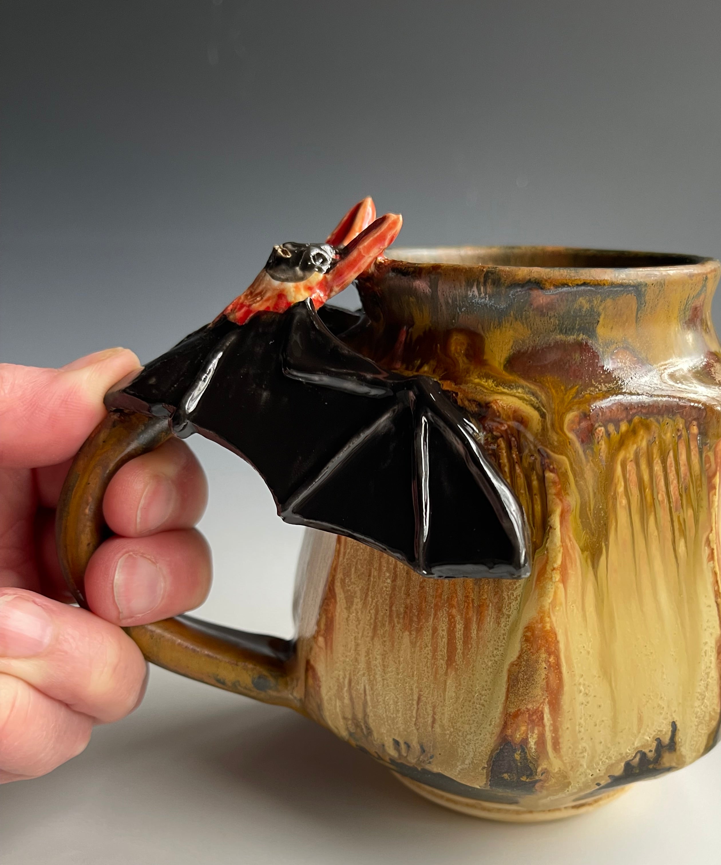Pottery mug with sculpted bat